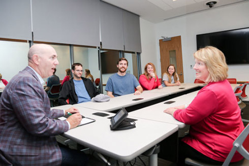 Faculty and students sitting at a table in the Consumer Insight and Sales Lab