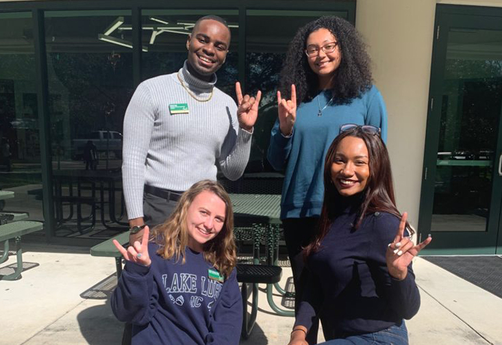 A group of students giving the "Go Bulls!" hand symbol. 