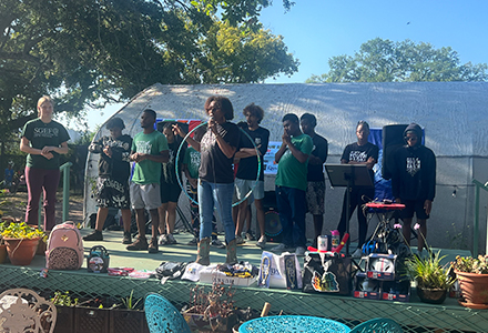 people speaking on stage at st pete youth farm on earth day