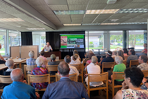 person speaking to a group of people attending the event