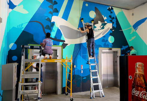 Students painting garage mural in parking garage.