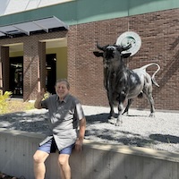 Gary Brown with the bull statue on campus.