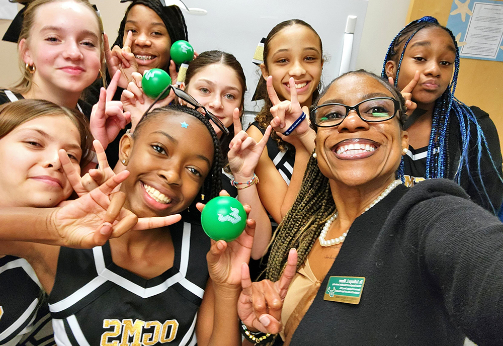 group of female cheerleaders giving the bulls hand gesture