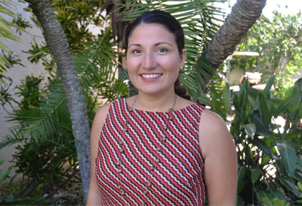 ann marie gunn standing in front of palm trees smiling