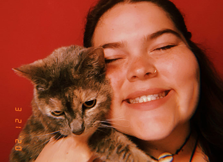 Jadzia Duarte holding a kitten up to her face