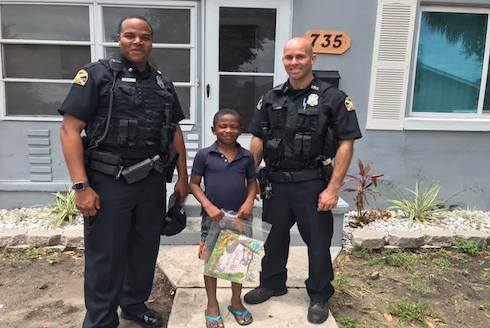 Police mentors delivering books to a child