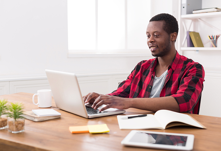 Male student typing on computer