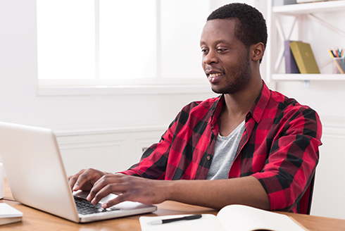 Male student typing on computer