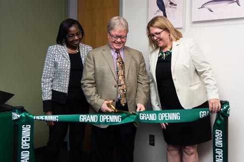 Interim Regional Vice Chancellor of Academic Affairs Olufunke Fontenot, Interim Regional Chancellor Martin Tadlock and Dean of the Nelson Poynter Memorial Library Catherine Cardwell cutting a ribbon at the grand opening.