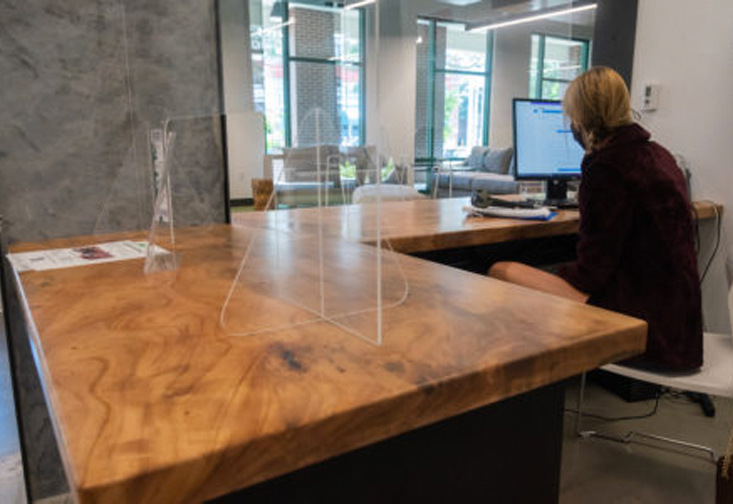 A person sitting at a desk made of reclaimed wood