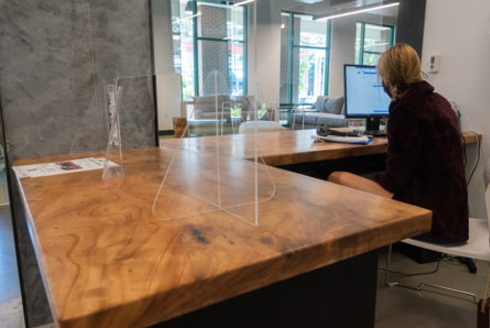 A person sitting at a desk made of reclaimed wood