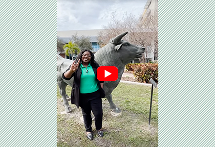 Sha'Tina Scott standing in front of the bull statue on USF St Pete campus