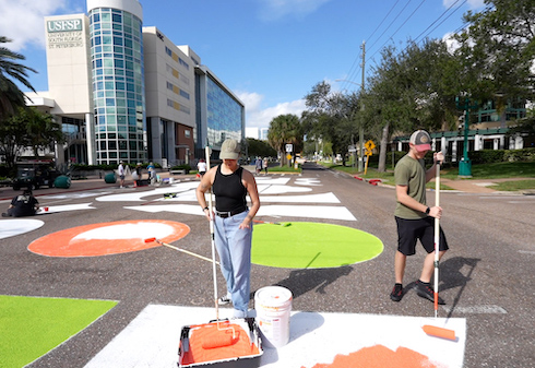 Students in the process of painting a new street mural on campus.