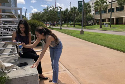 Students Frances Rodriguez and Shayra Antia set up their measuring devices at USFSP.