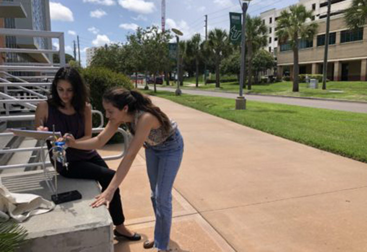 Students Frances Rodriguez and Shayra Antia set up their measuring devices at USFSP.
