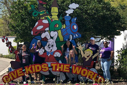 Students in front of a sign reading