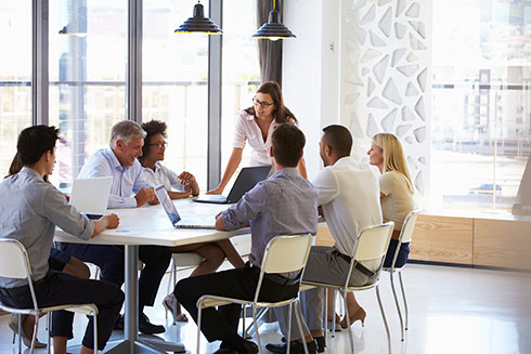 People sitting at a table with laptops open