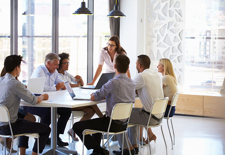 People sitting at a table with laptops open