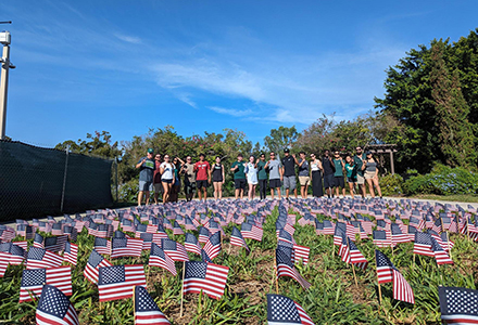 group of adults in a field of USA flag in the ground