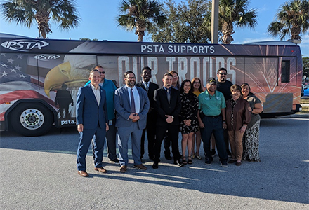 group of people standing in front of the PSTA veterans bus