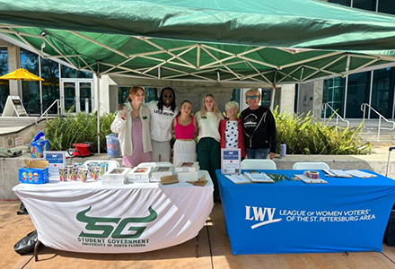 table event on harbor walk showing student government and center for civic engagement members