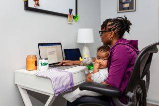 Woman on laptop with a baby in her lap