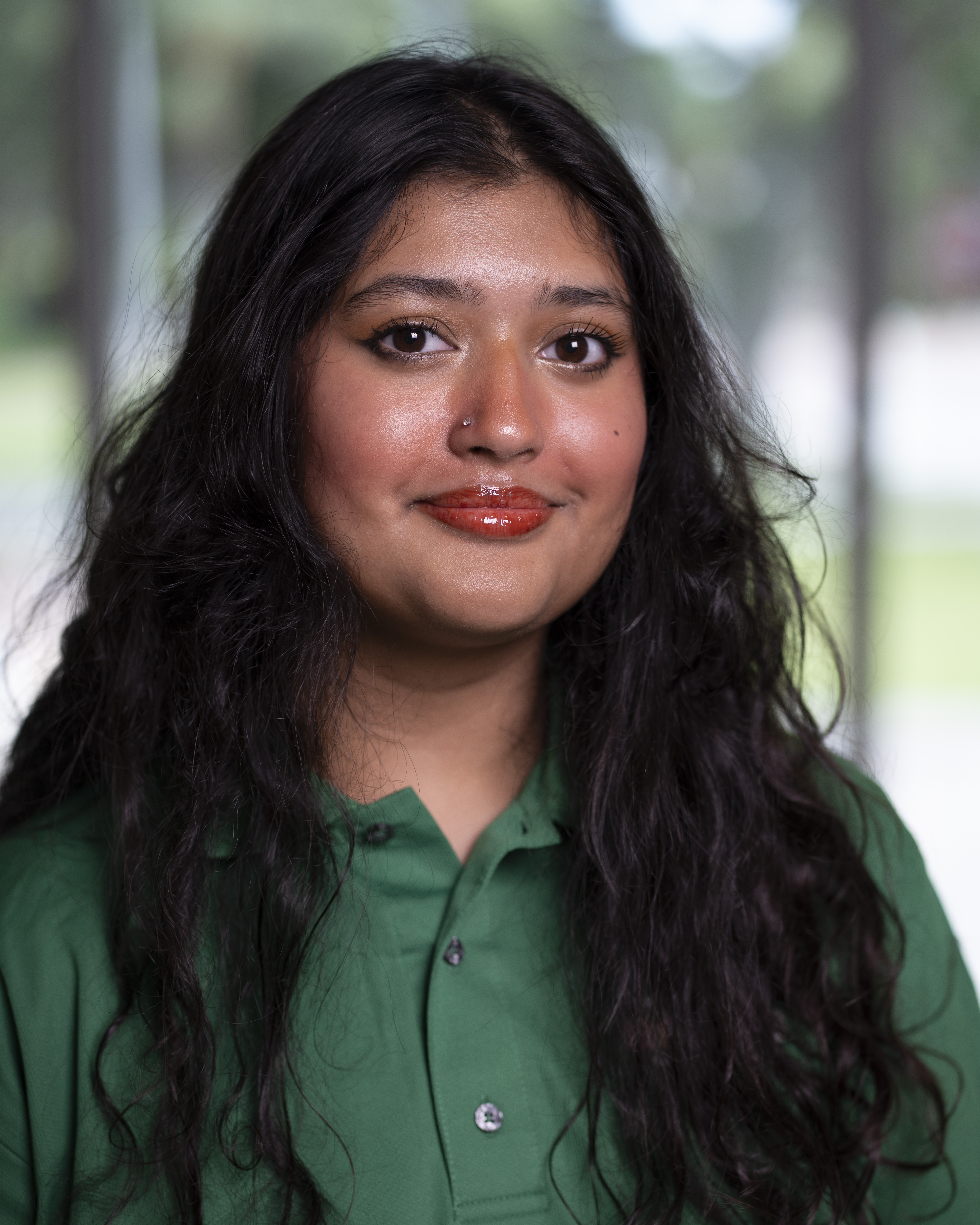 Woman in green polo smiles at camera.