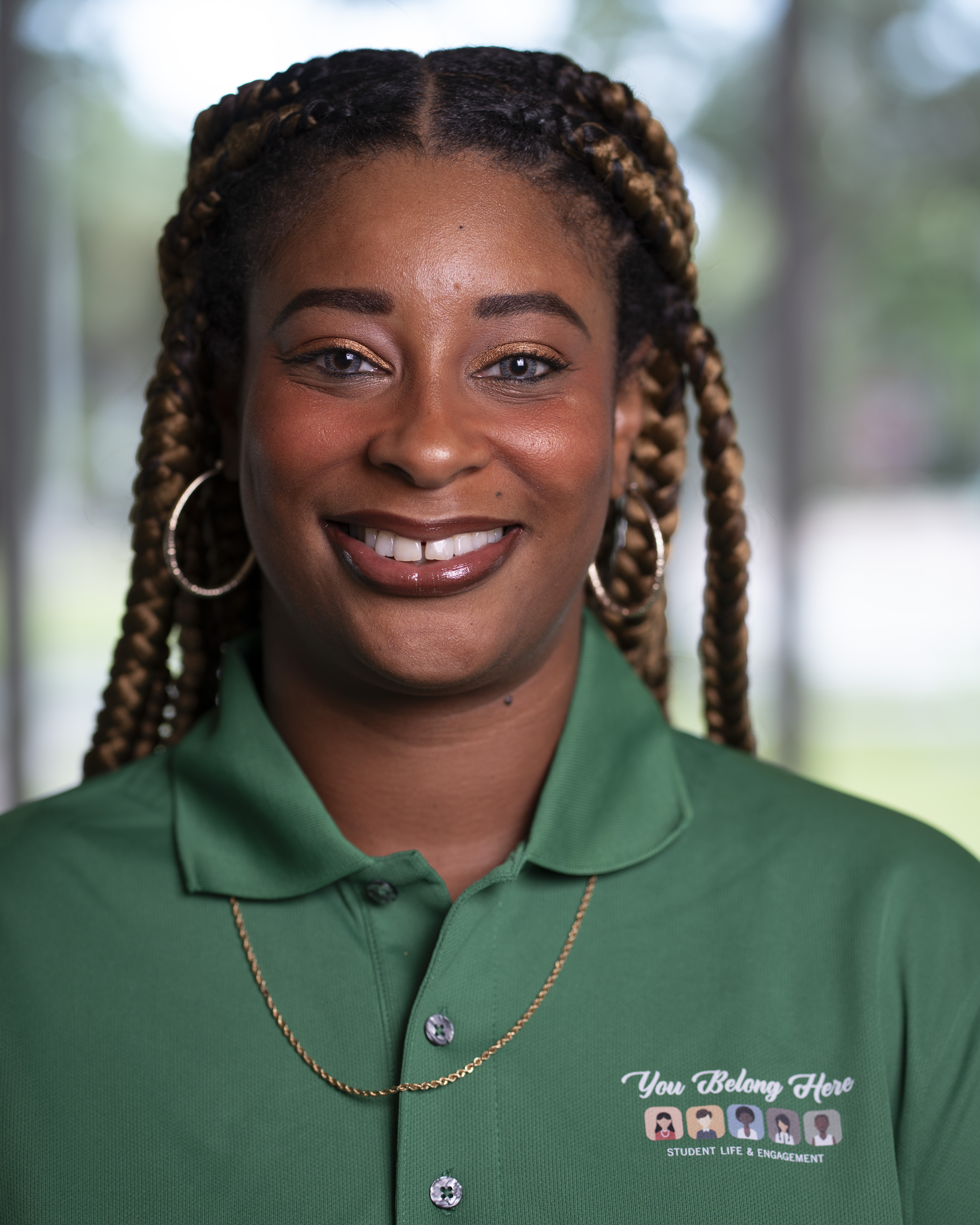 Woman wearing green polo smiles at camera.