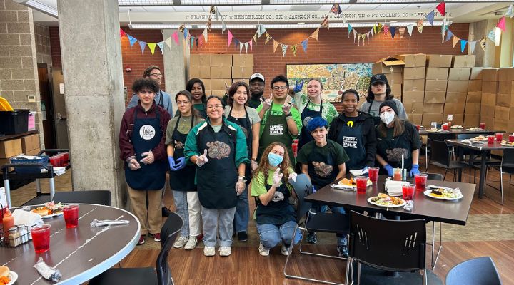 Large group of students posing for photo in cafeteria. 