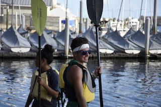 Students with paddles along the waterfront